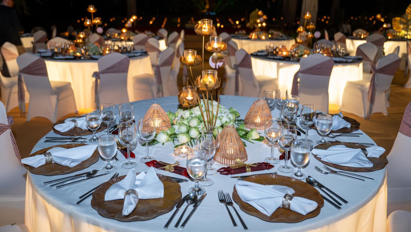A dinner table set with candles and lotus flowers